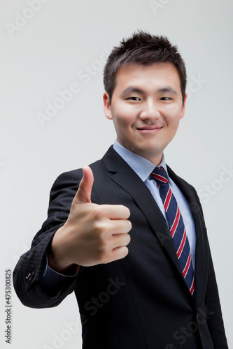 Korean business man wearing a suit and holding his thumb up photo