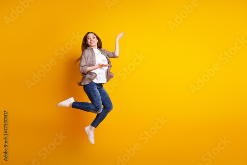 Full body profile side photo of young girl demonstrate product offer advertise isolated over yellow color background