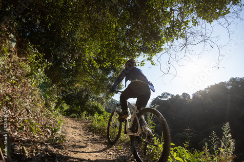 Woman riding bike in sunrise forest