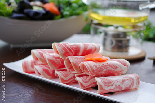 Sliced lamb mutton rolls for shabu shabu hot pot on white plate photo