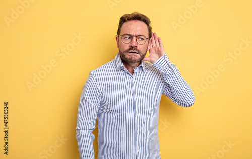 Принти на полотні middle age handsome man looking serious and curious, listening, trying to hear a