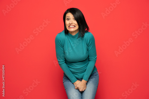 Young woman pressed her hands to the lower abdomen. Medical concept photo