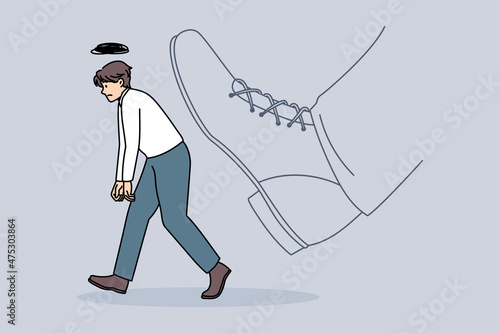 Being fired and kicked out concept. Young stressed sad man worker office manager going away with huge boot shoe kicking him out vector illustration 