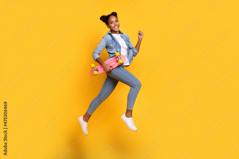 Full body profile side photo of young african lady good mood go walk run hold skateboard isolated over yellow color background