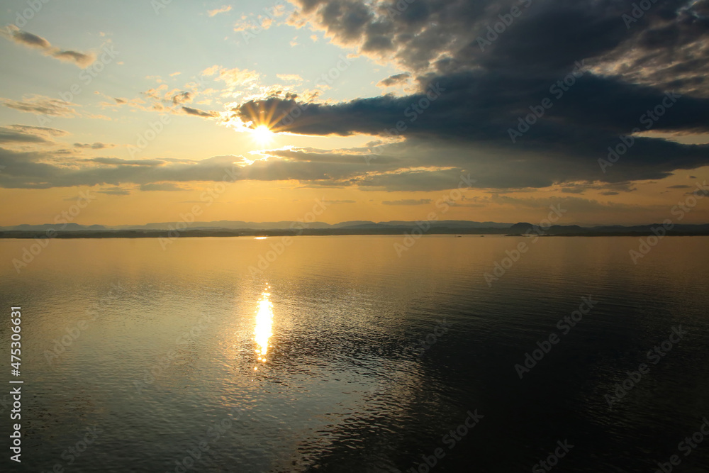 Beautiful sunrise over the ocean with orange early morning light and reflections in the sea, Sognefjord, the country’s longest and deepest fjord, Baltic cruise,  North Sea.