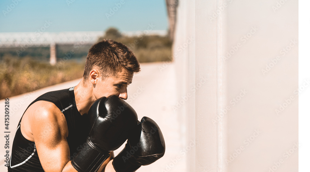 Man exercising and fighting in outside, boxer in gloves. male boxer portrait Man exercising and fighting in outside, boxer in gloves. male boxer portrait