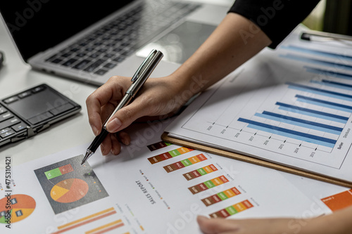 A business finance woman is reviewing a company's financial documents prepared by the Finance Department for a meeting with business partners. Concept of validating the accuracy of financial numbers.