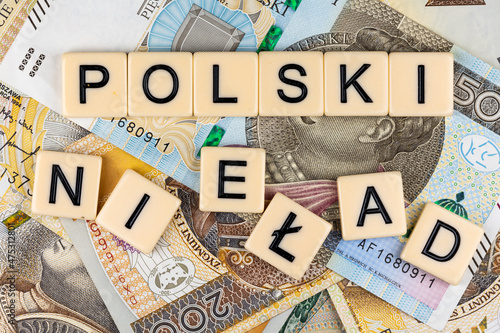 The sentence "Polski Ład" translated as "Polish Order" and many Polish banknotes. New taxation rules in Poland. Photo taken under artificial, soft light