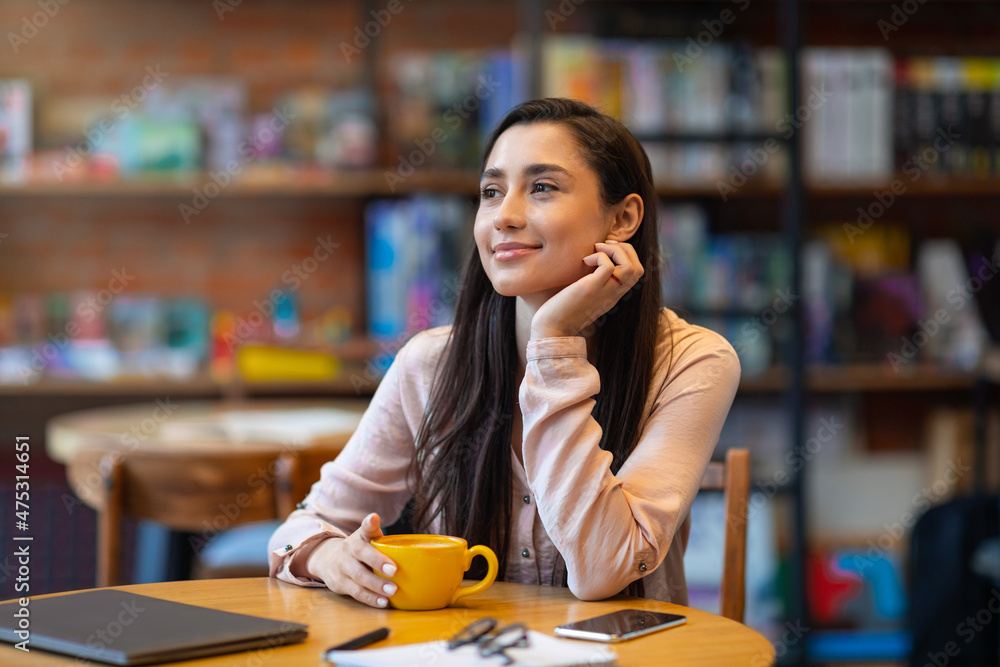 Dreamy arab lady using laptop at cafe, drinking coffee and dreaming, studying or working distantly Dreamy arab lady using laptop at cafe, drinking coffee and dreaming, studying or working distantly