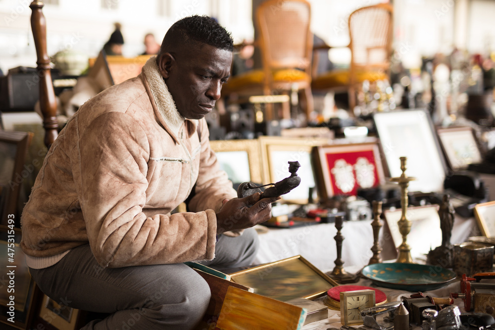 African American man chooses antiques on the flea market African American man chooses antiques on the flea market