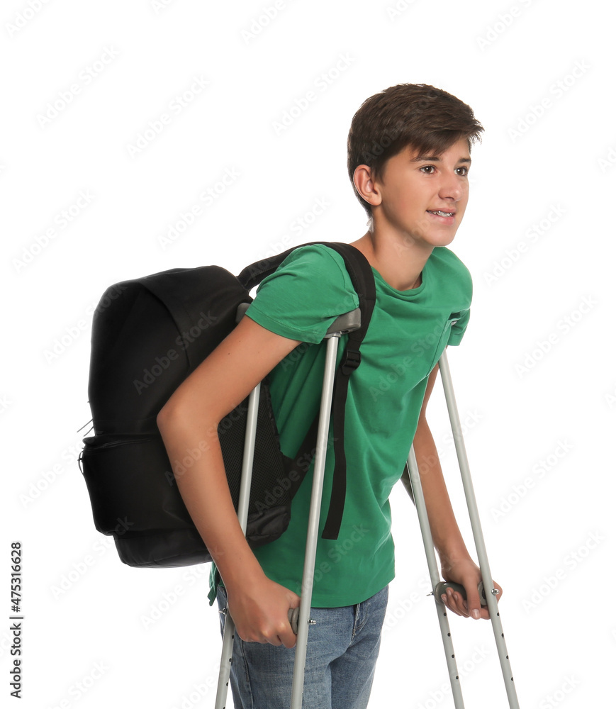 Teenage boy with injured leg using crutches on white background