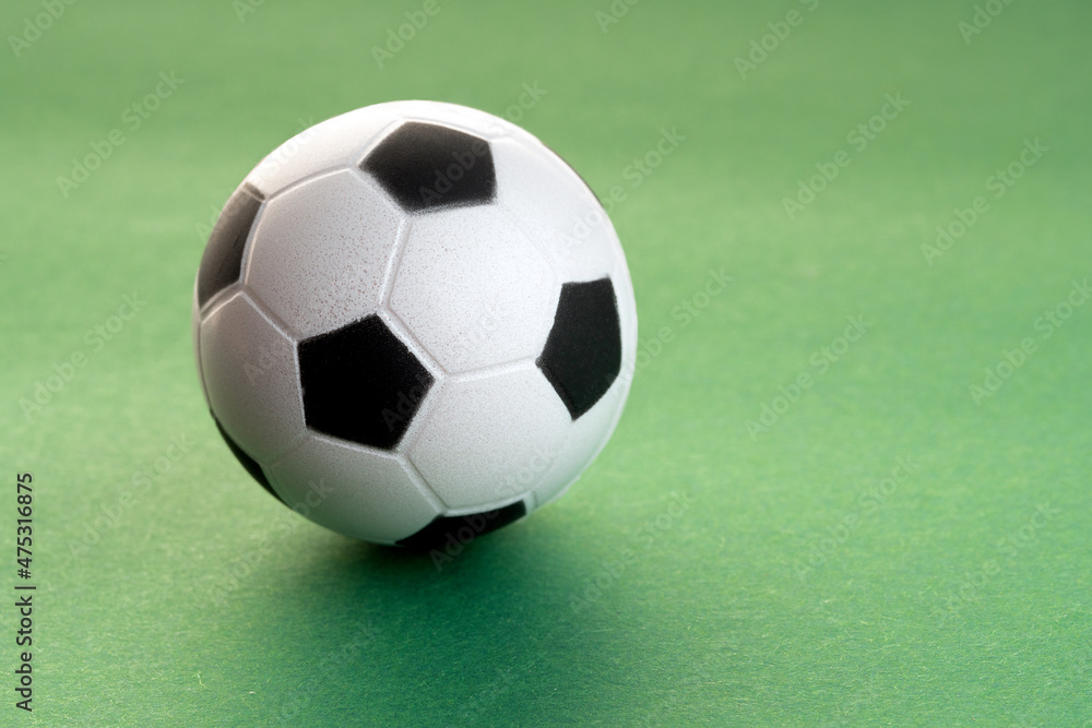 Toy soccer ball on the sheet of green paper Toy soccer ball on the sheet of green paper