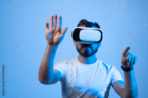 Young bearded man with VR glasses playing a video games in virtual reality.