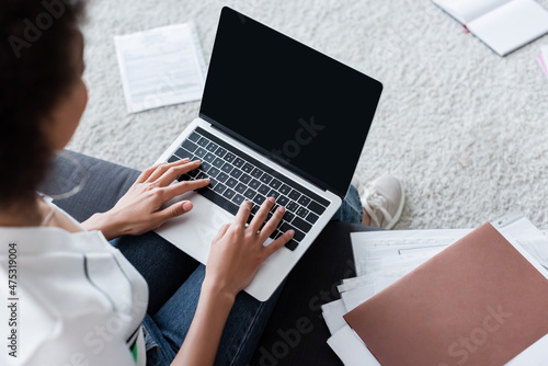 top view of african american freelancer typing on laptop keyboard