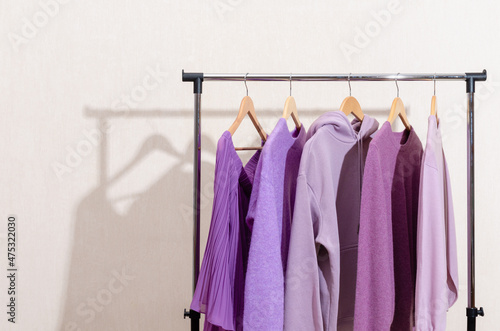 Fashionable tops in trendy purple  very peri  lavender colors hanging on a shopping rail. Styling  circular economy.