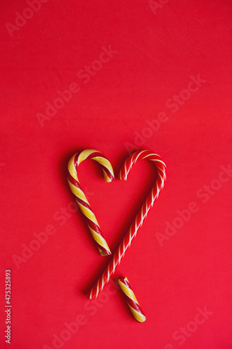 red heart shaped lollipop. Heart shaped with christmas candy canes on red vertical background