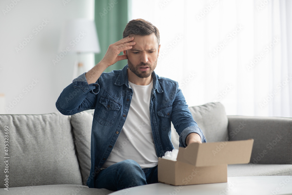Disappointed man customer checking mail box at home Disappointed man customer checking mail box at home