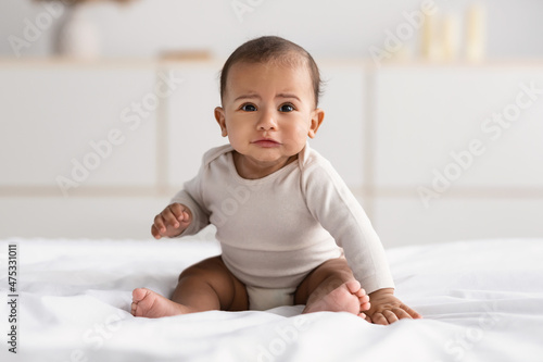 Portrait of sad African American baby crying alone