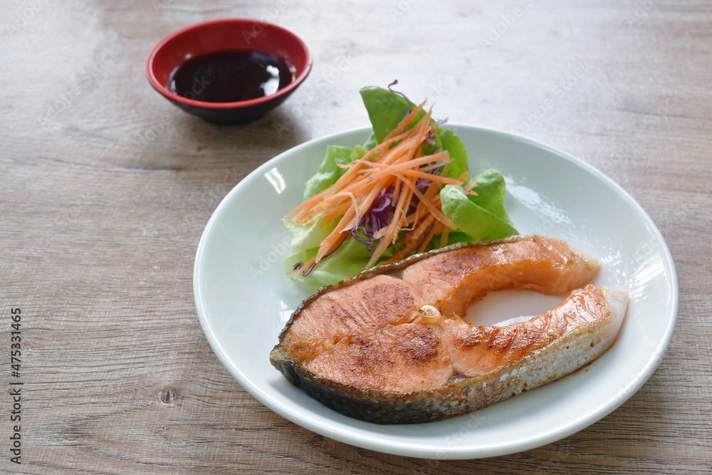 grilled salmon steak dipping teriyaki sauce with fresh vegetable salad on plate grilled salmon steak dipping teriyaki sauce with fresh vegetable salad on plate
