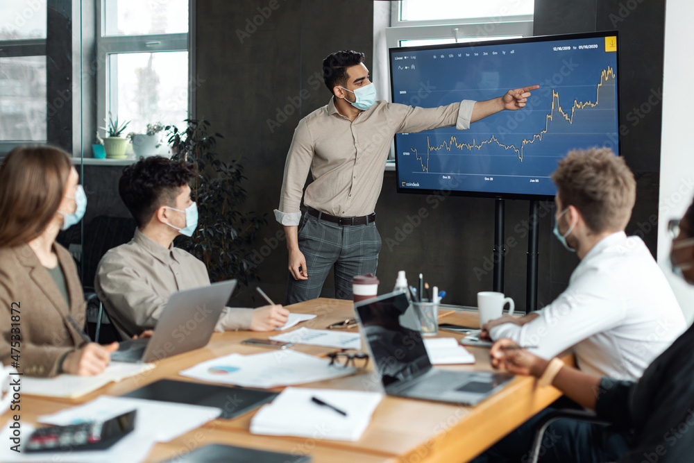 Colleagues having meeting in boardroom, businessman showing graph Colleagues having meeting in boardroom, businessman showing graph