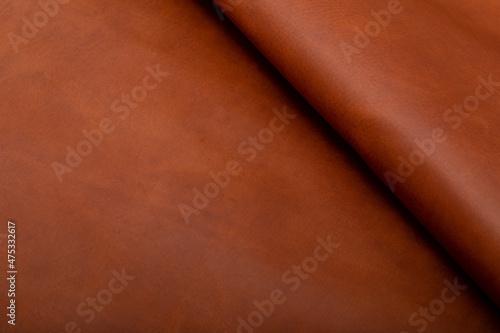 Brown folded natural cow leather on the wooden table	
