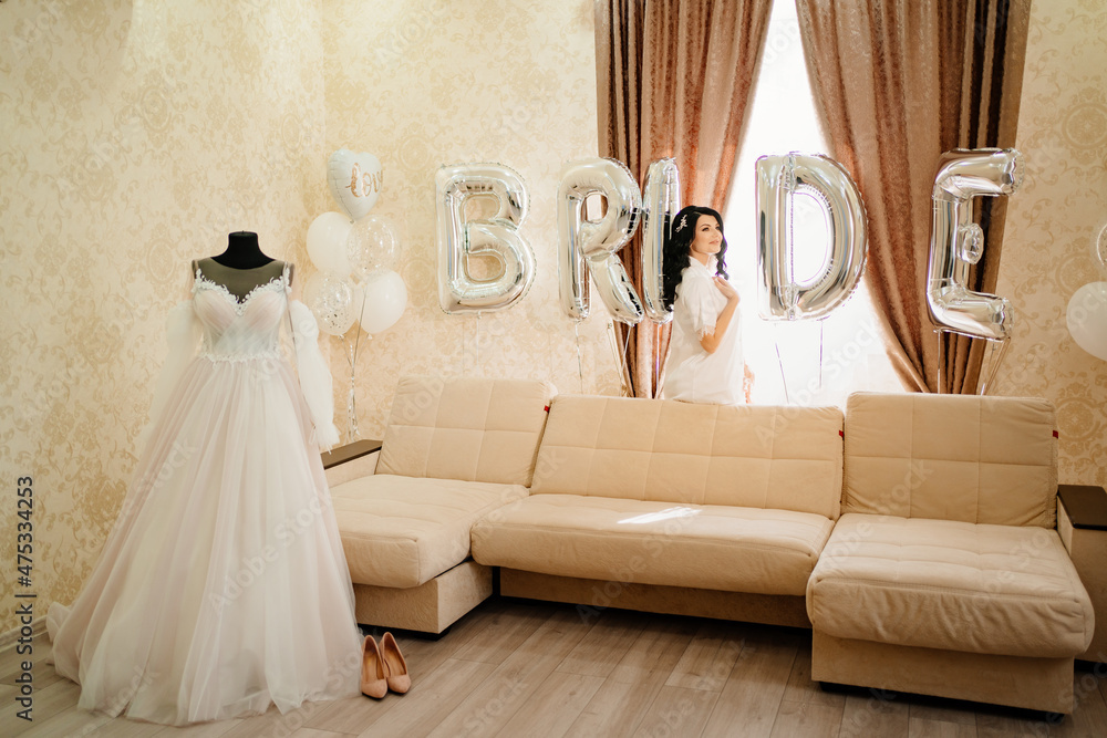 bride in white coat in a room of her 