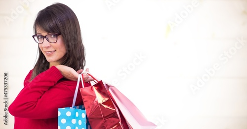 Composite image of caucasian woman carrying shopping bags against textured background