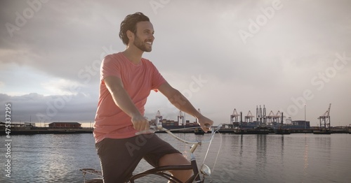 Composite image of caucasian man riding a bicycle against lake in background