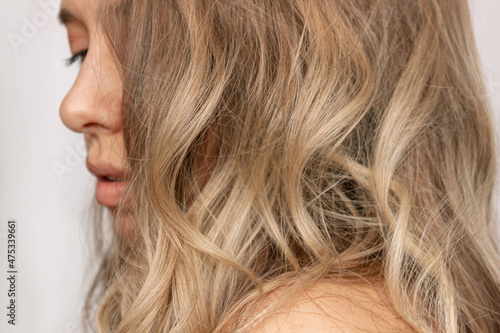Foto Close-up of the wavy blonde hair of a young blonde woman isolated on a white background