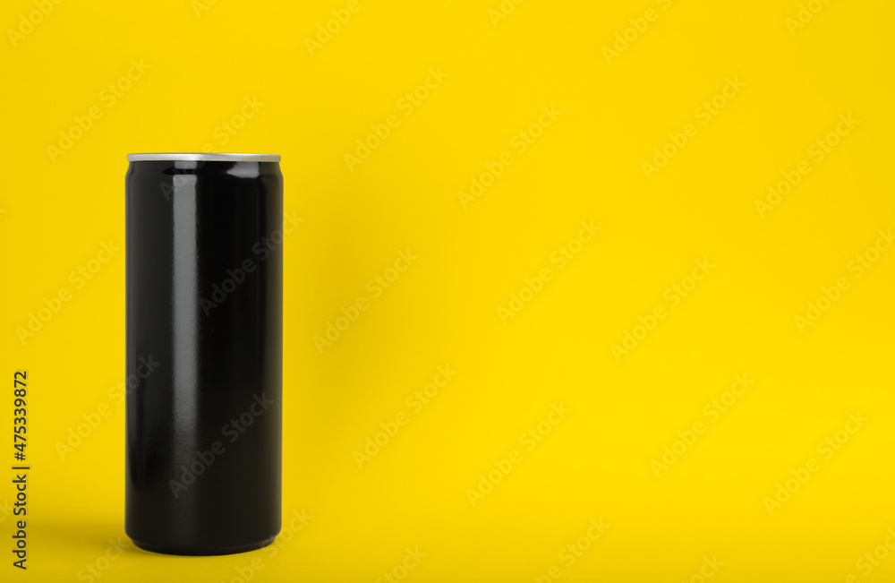 Black can of energy drink on yellow background. Space for text Black can of energy drink on yellow background. Space for text