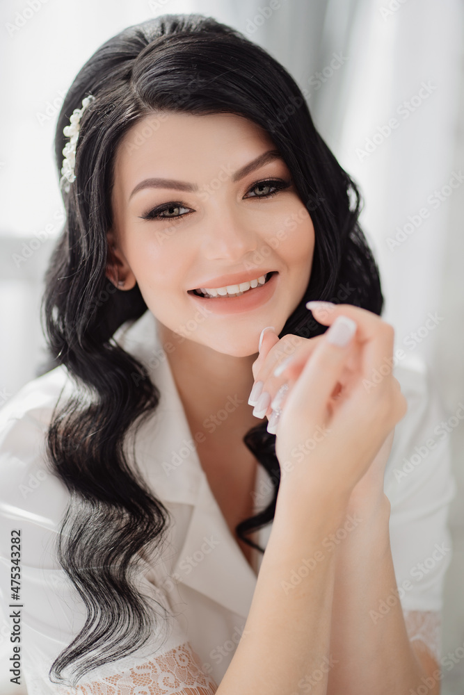 the face of a beautiful brunette bride with long hair and a white hairpin. the face of a beautiful brunette bride with long hair and a white hairpin.