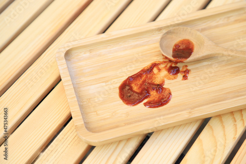 Dirty spicy sauce stain on wooden tray from using in serving. photo  for cleaning  concept of houeswork and clean tool product photo