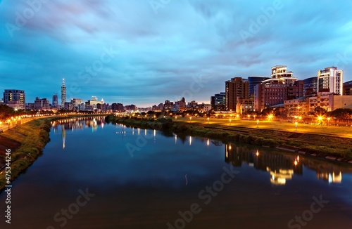 Night view of Taipei City by riverside with skyscrapers and beautiful reflections on smooth water ~ Landmarks of Taipei 101 Tower, Keelung River, Xinyi District and downtown area at dusk © AaronPlayStation