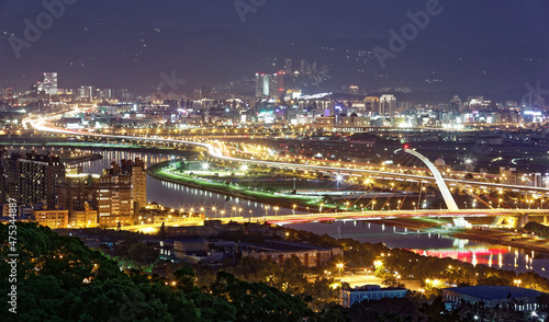 Aerial panorama of Taipei Downtown at night with Dazhi Bridge over Keelung River  parks and highways along the riverside and skyscrapers in Nangang area at dusk   A romantic night scape of Taipei City