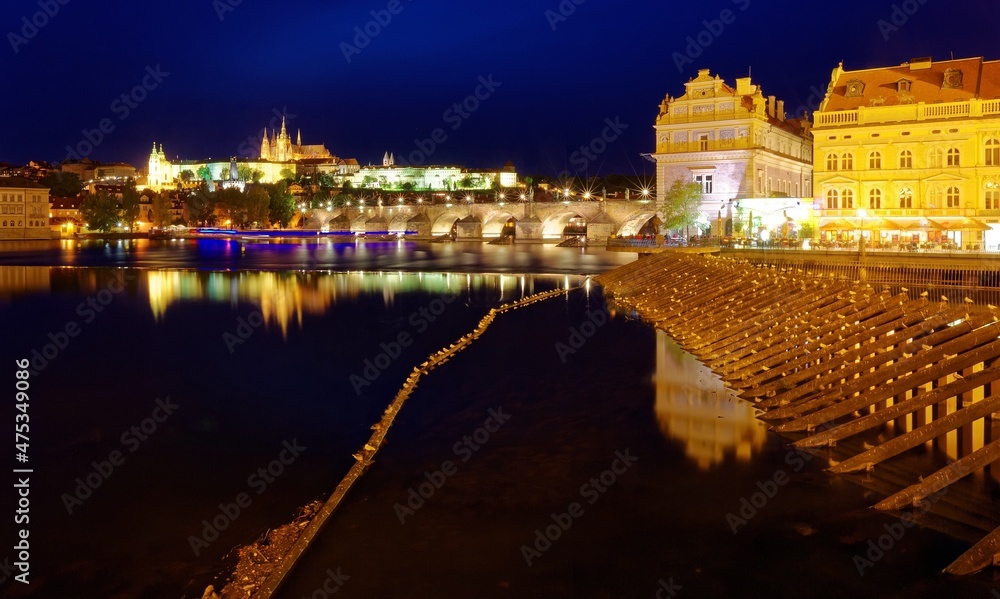 Beautiful night scape of Charles Bridge over Vltava River with Prague Castle in background, Bedrich Smetana Museum by riverside & reflections of lights on the water in Old Town Prague, Czech Republic