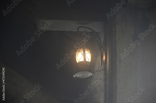 Vintage lantern with a light bulb inside hangs on the wall