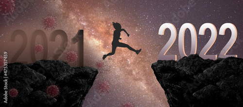 Fényképezés Silhouette man or woman jumping between year 2021 to year 2022 years