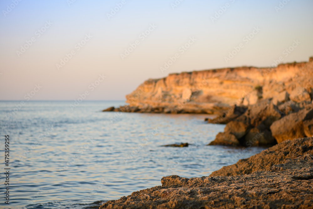 Summer sunset over the rocky coast of the sea