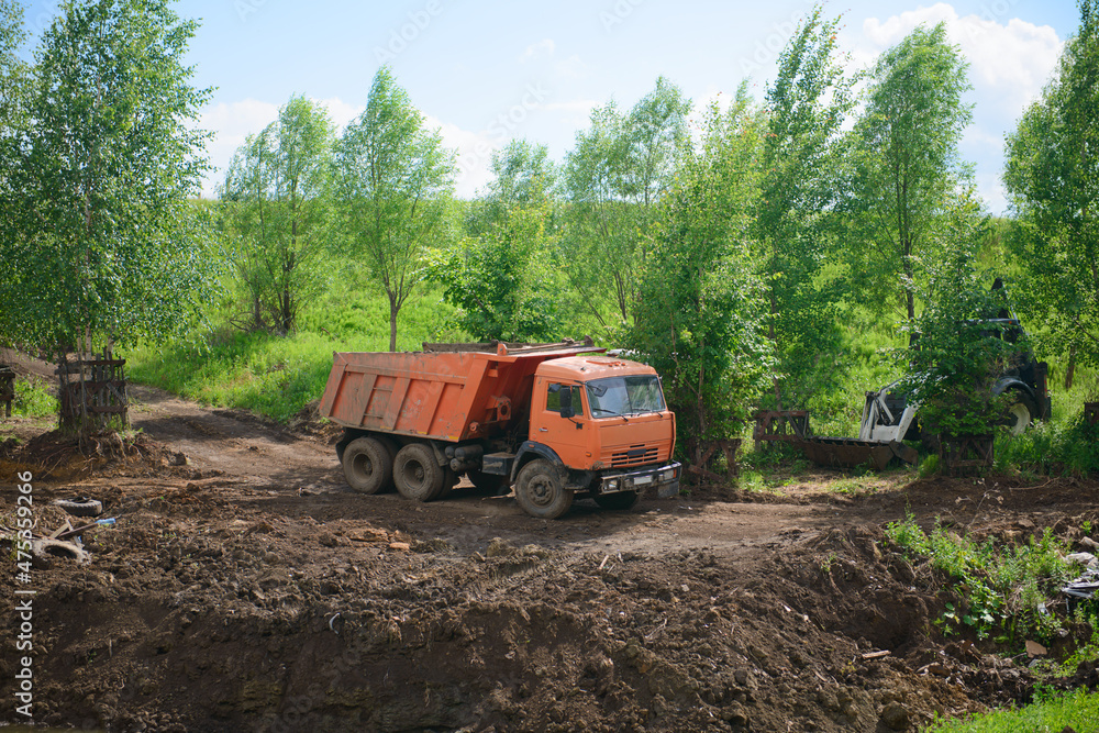 Dump truck and tractor on earthworks in a ravine