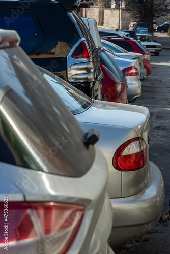 Closeup of rear, back side of golden car with other cars parking in outdoor parking area. © Oleh Marchak