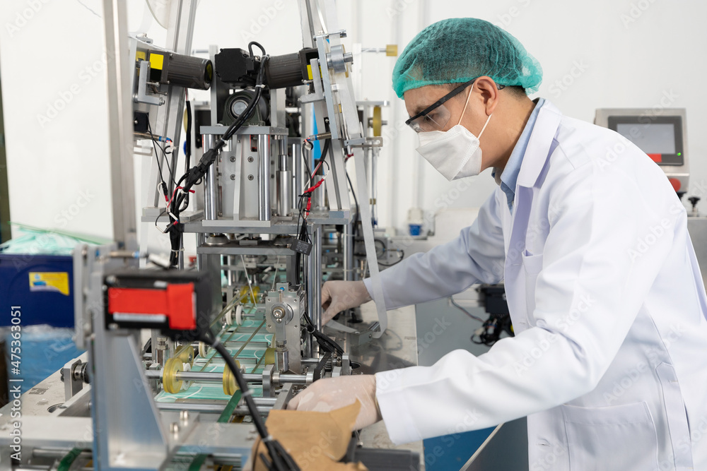 factory worker using machine control panel and producing medical face masks in factory factory worker using machine control panel and producing medical face masks in factory