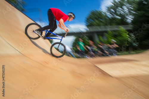 Bmx rider jumping over on a U ramp in a skatepark photo