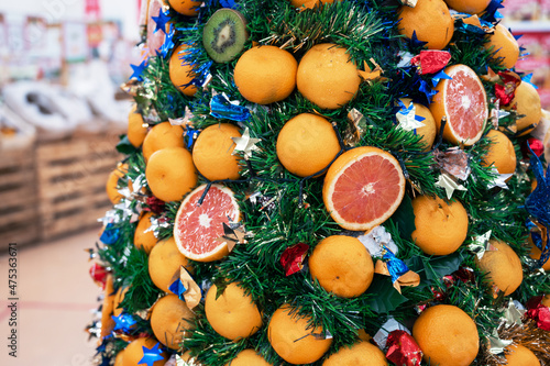New year fir tree decorated with fruits in supermarket