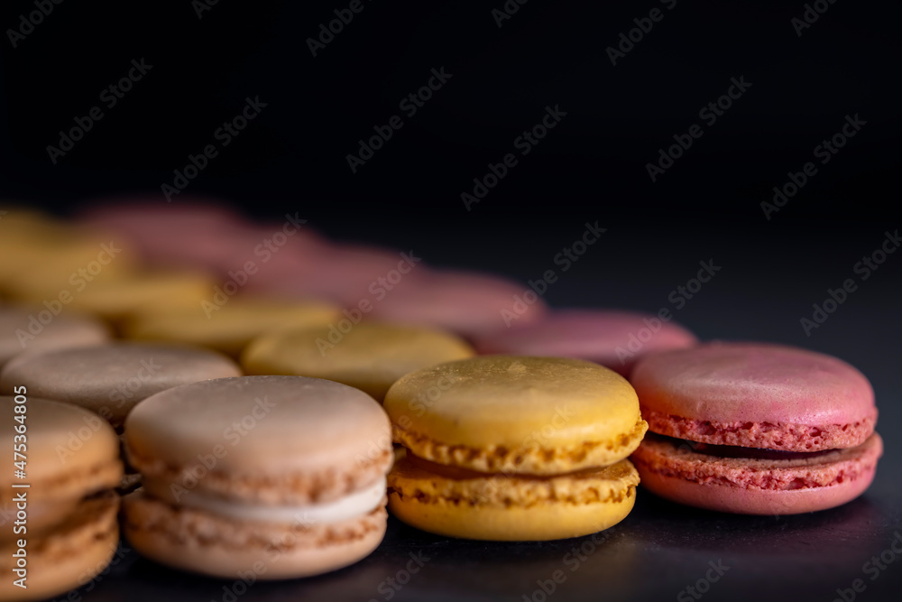 Fototapeta premium chocolate, coffee, vanilla, lemon and strawberry macaroons on black background