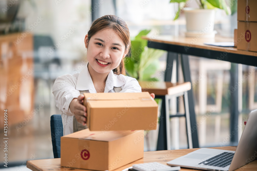 Small start-up business owners using computers at work, freelancers, saleswoman, checking production orders. Pack products for delivery to customers Small start-up business owners using computers at work, freelancers, saleswoman, checking production orders. Pack products for delivery to customers