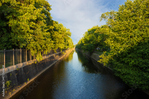 Summer evening landscape with Obvodny canal among green foliage in Kronstadt, Russia