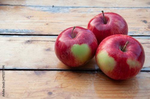 In the foreground are three apples with a green heart on the side. High quality photo