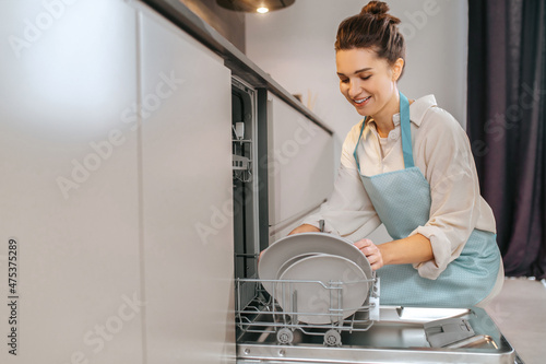 Housewife washing plates in the dishwasher