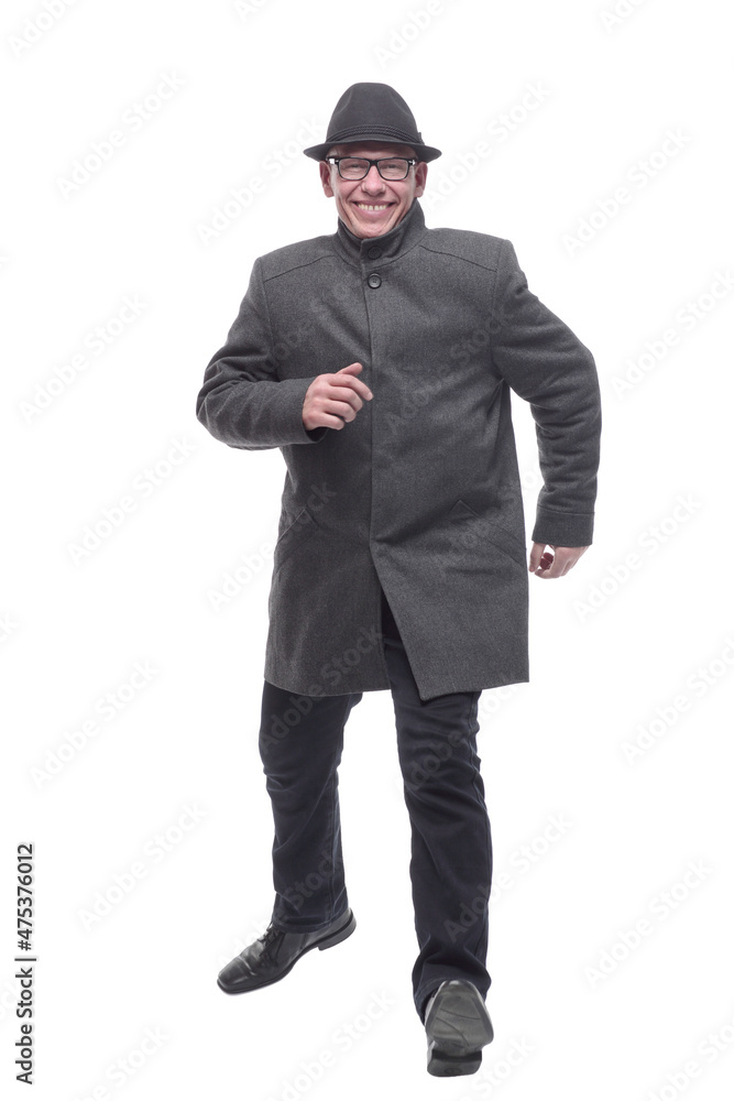 cheerful man in a hat and autumn coat striding forward . cheerful man in a hat and autumn coat striding forward .