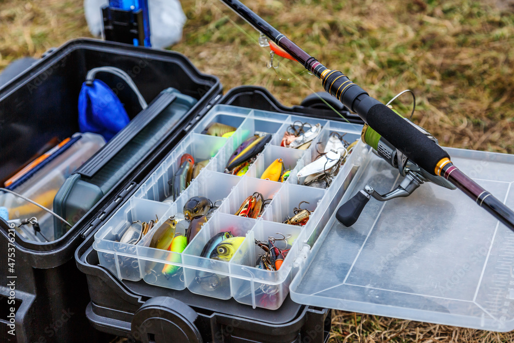 A large fisherman's tackle box fully stocked with lures and gear for fishing .fishing lures and accessories. fishing spinning. Kit of fishing lures.  Photos